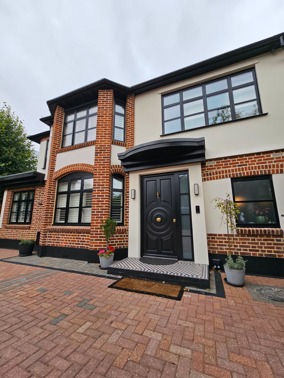 Black ornate steel door with medallion on driveway