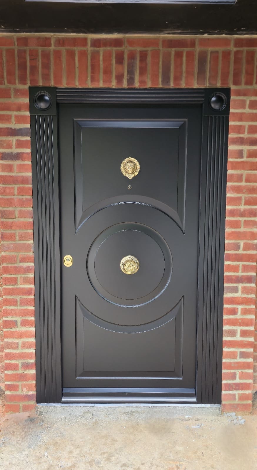 Black ornate steel door with circular fluted design