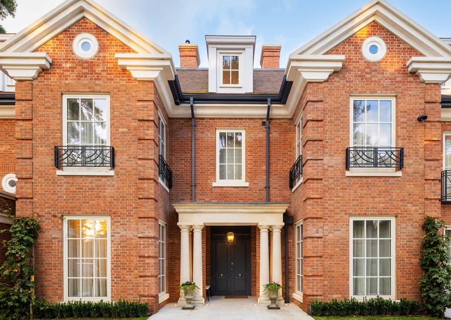 Grand mansion entrance with black steel door flanked by classical columns